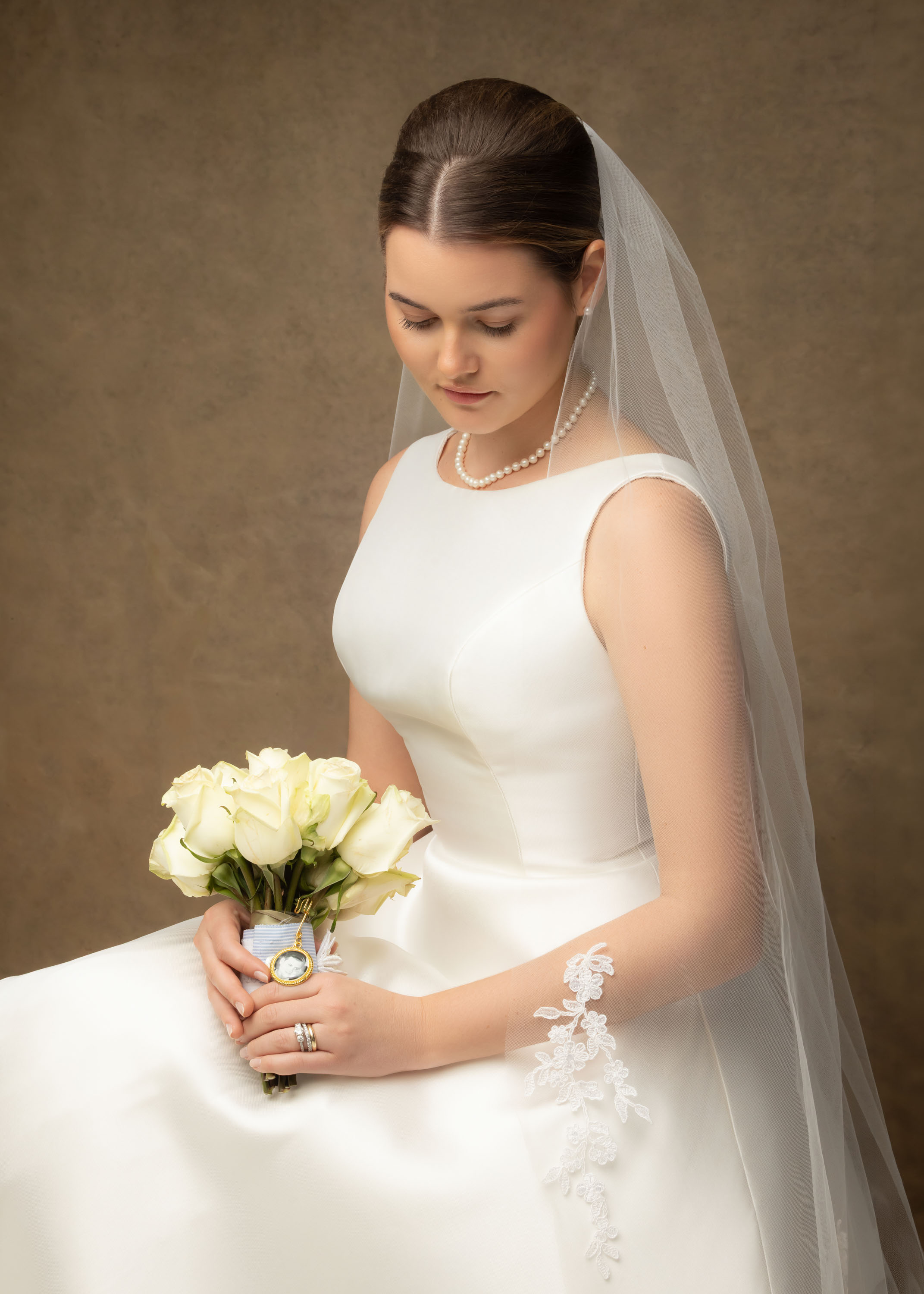 Bride seated with a bouquet in her wedding dress