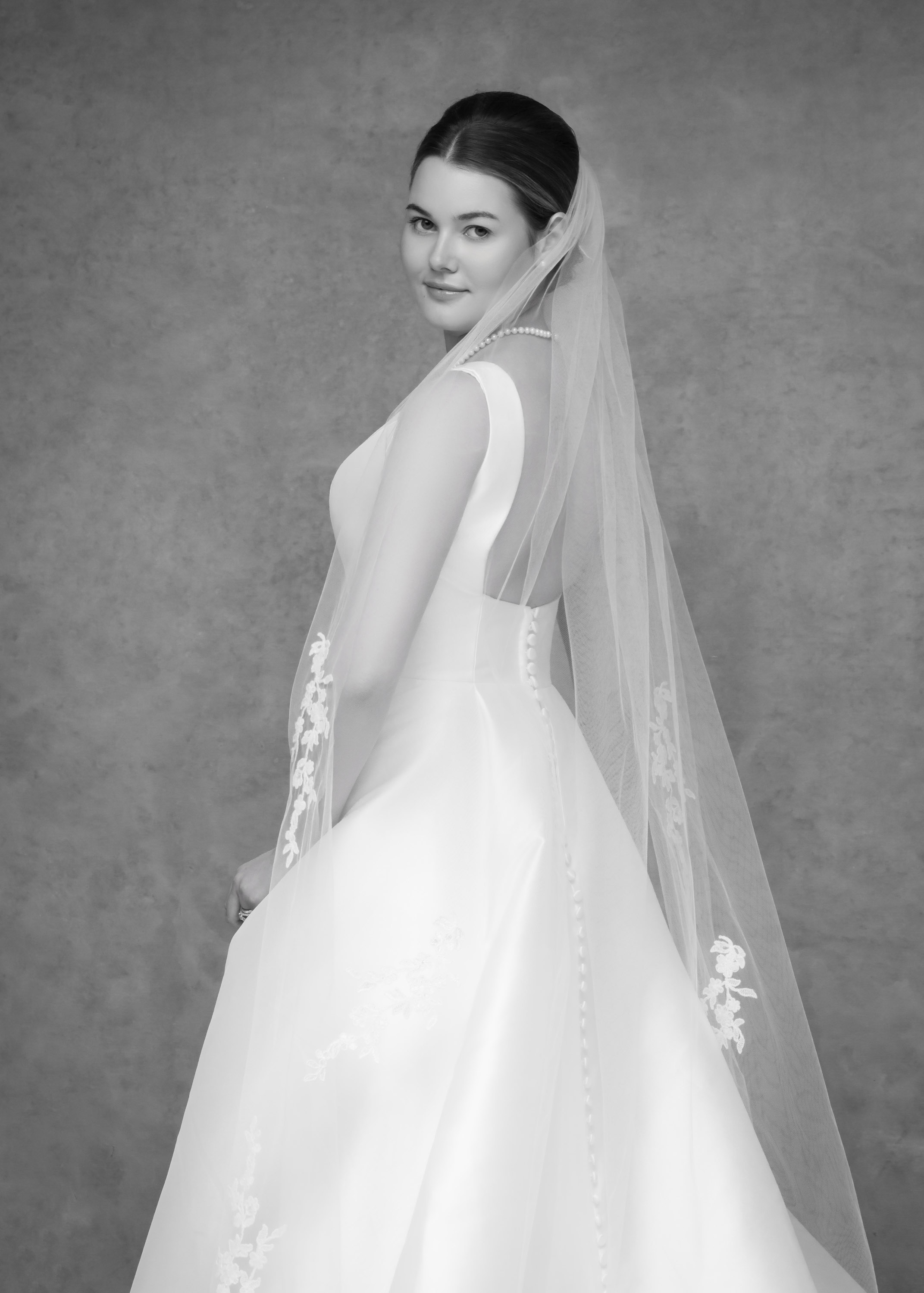 Black-and-white bridal portrait showing the gown and veil