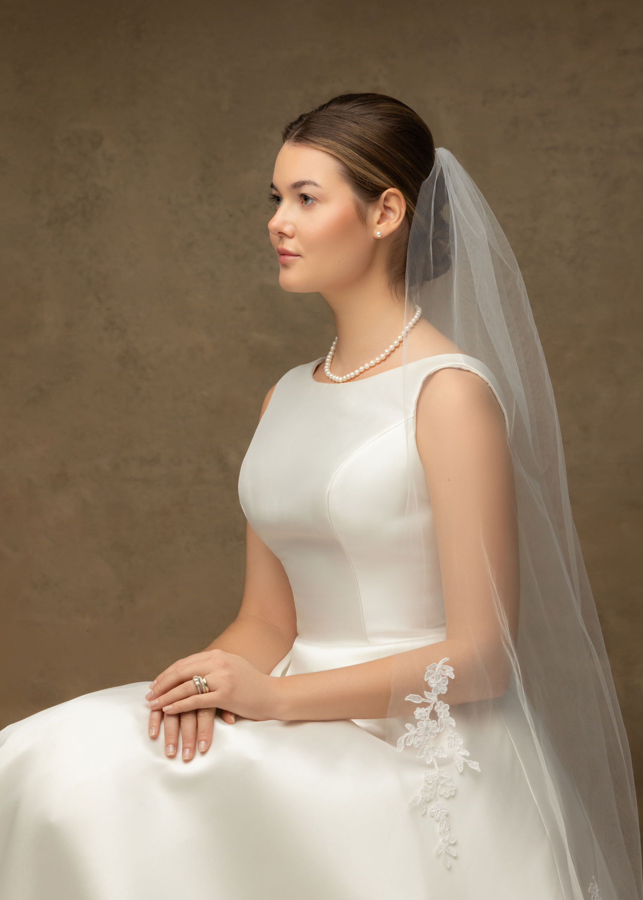Bride seated in her wedding dress and veil for an individual portrait
