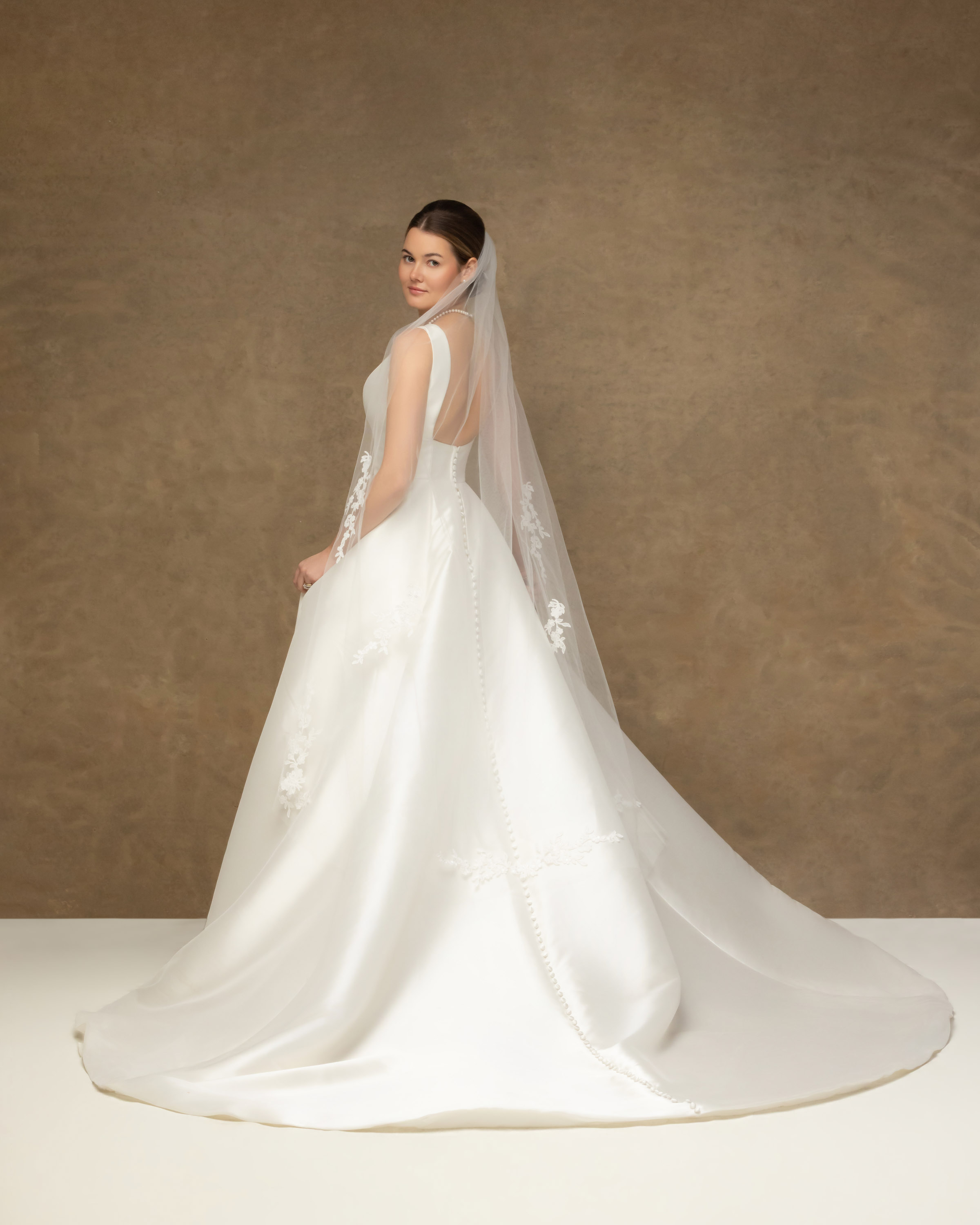 Bride in her wedding gown and veil in a studio portrait made after the wedding