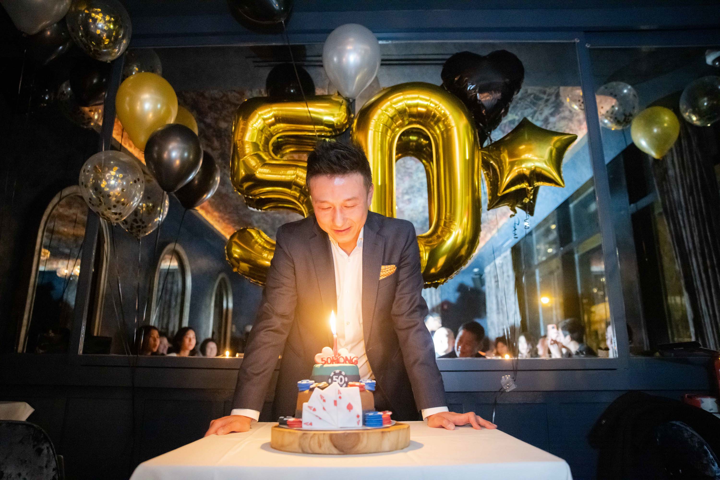 Man with a birthday cake at his fiftieth celebration