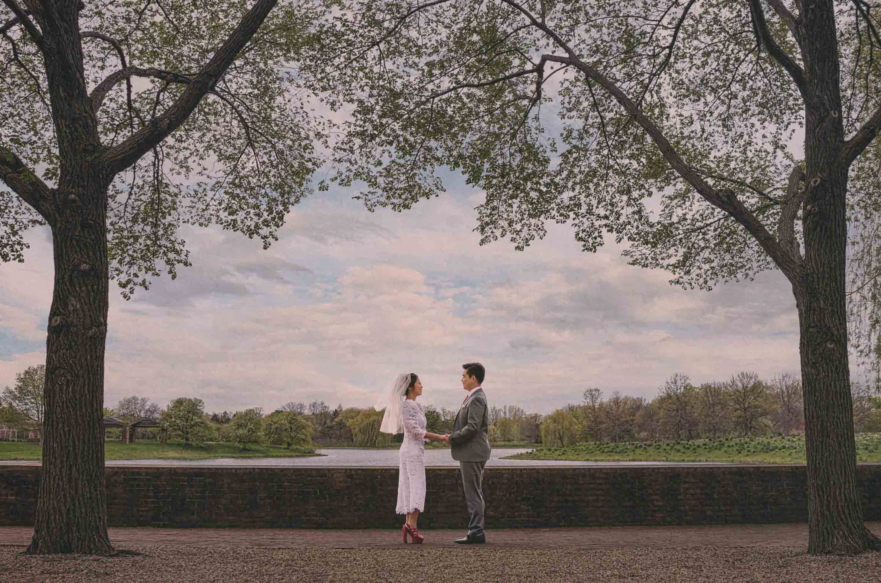 Couple photographed together beneath trees outdoors