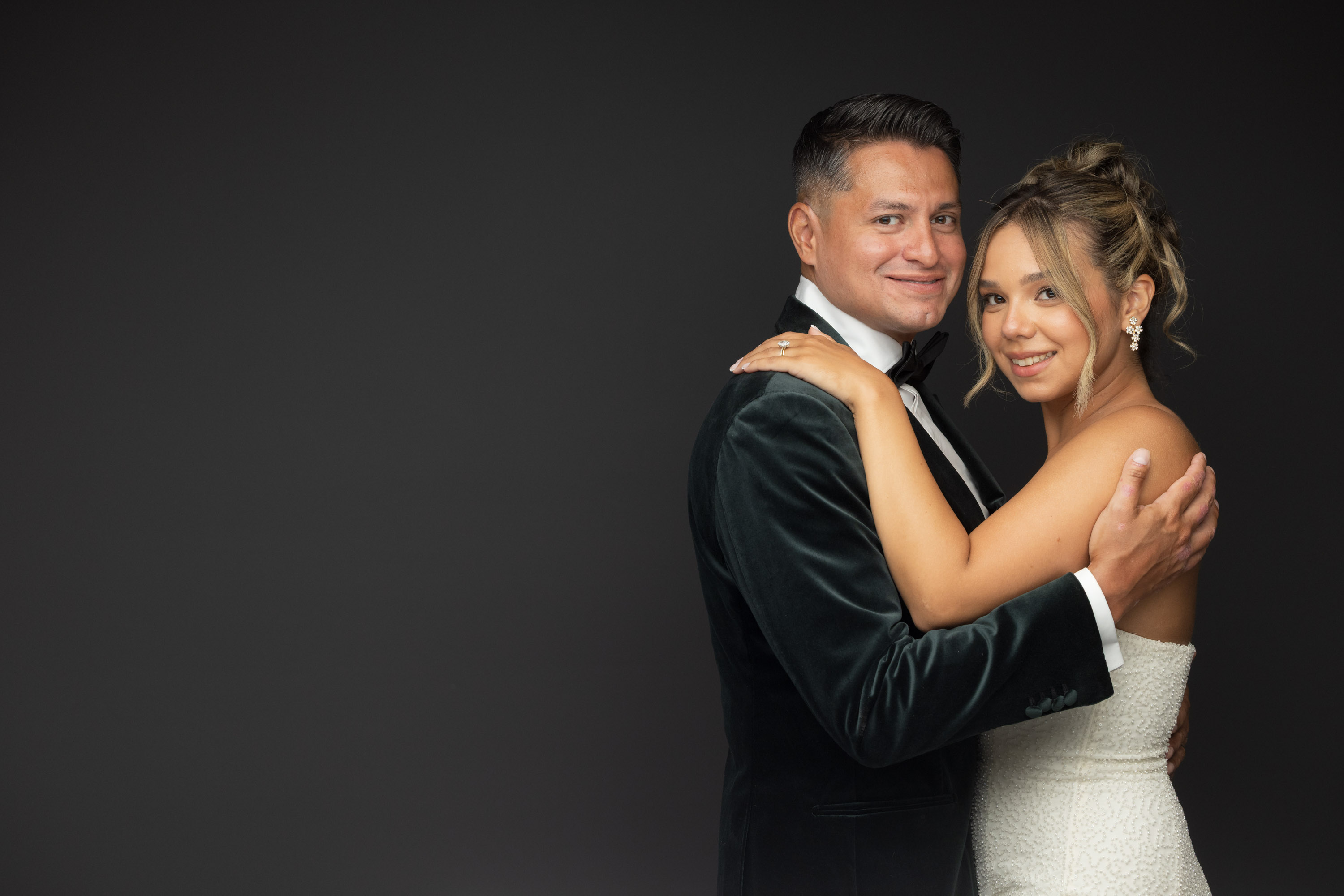 Couple in wedding clothes against a studio backdrop