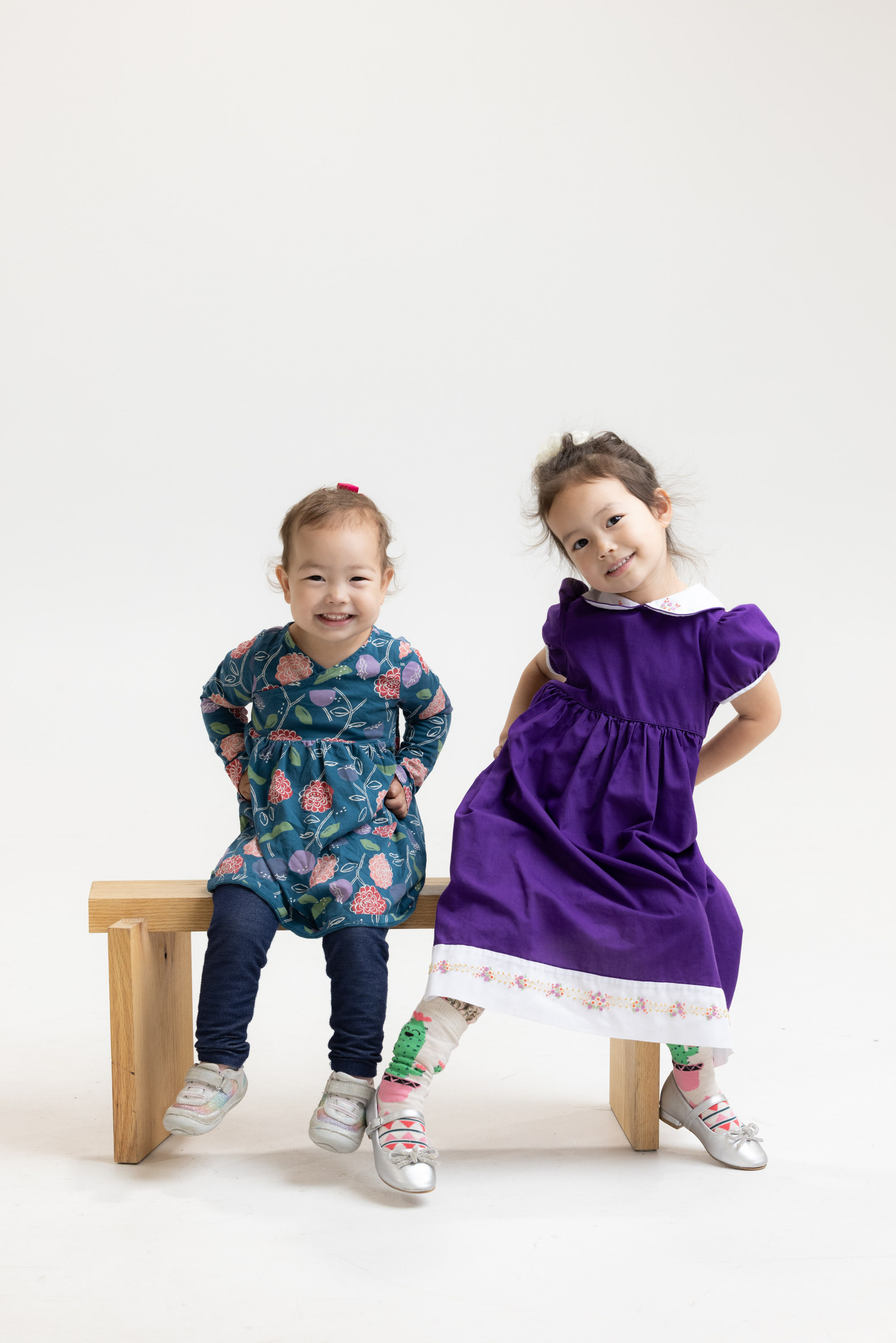 Two young children sitting together on a wooden bench