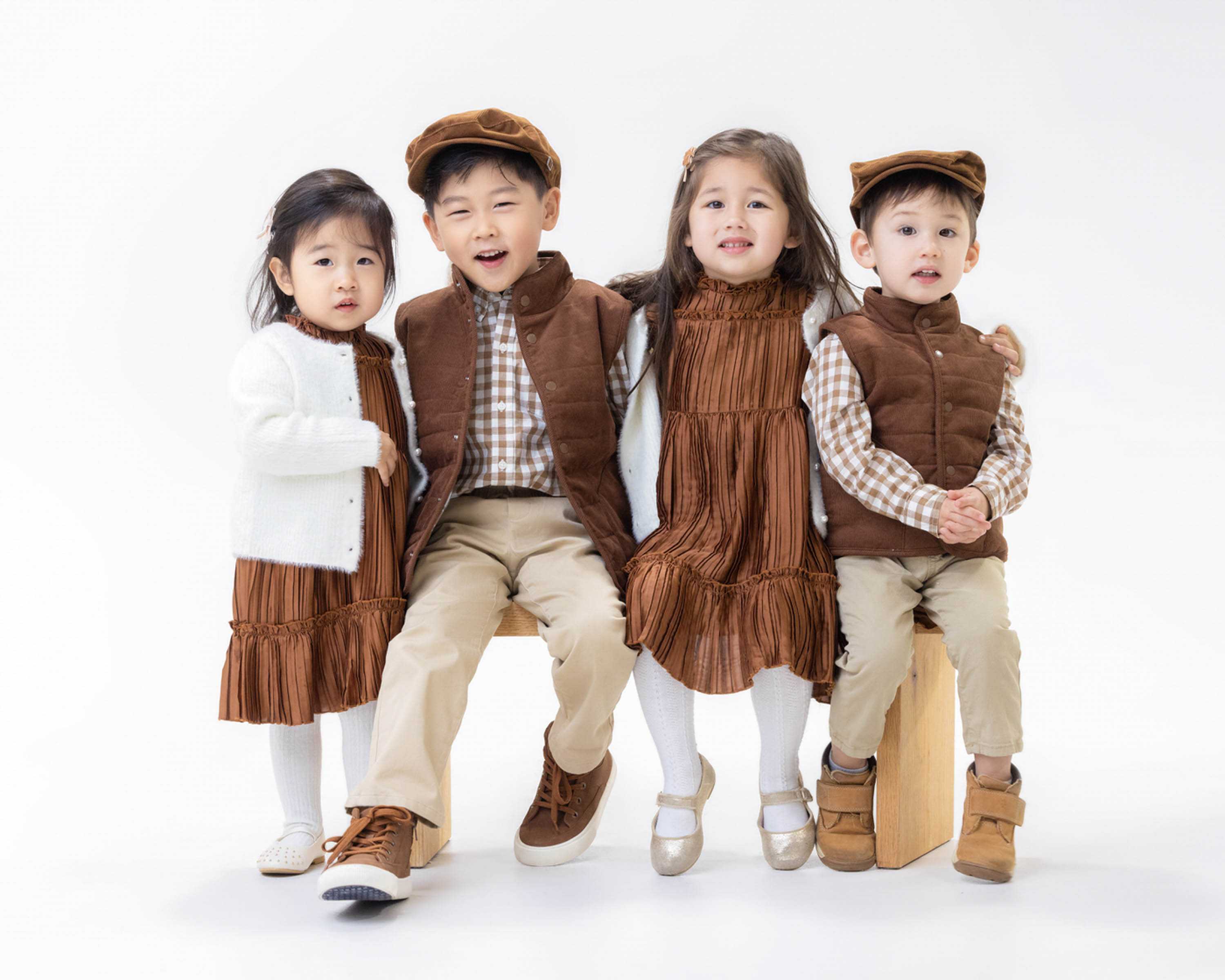 Four children sitting together in a studio