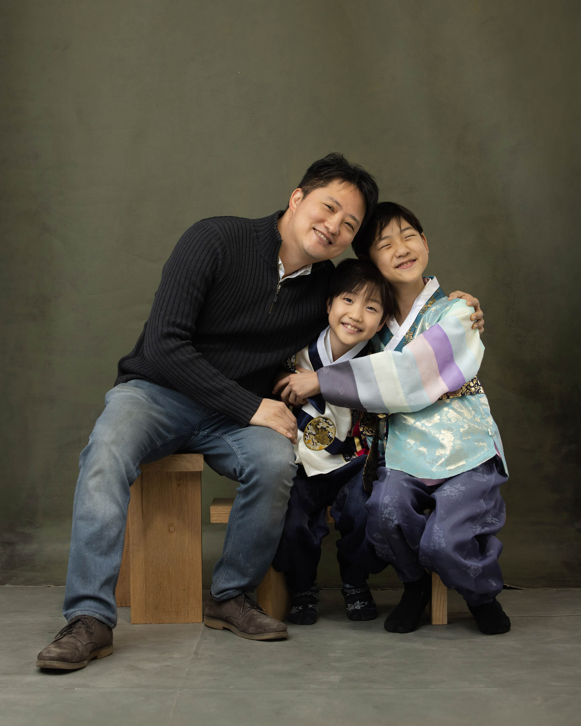 Father embracing two children in a studio portrait