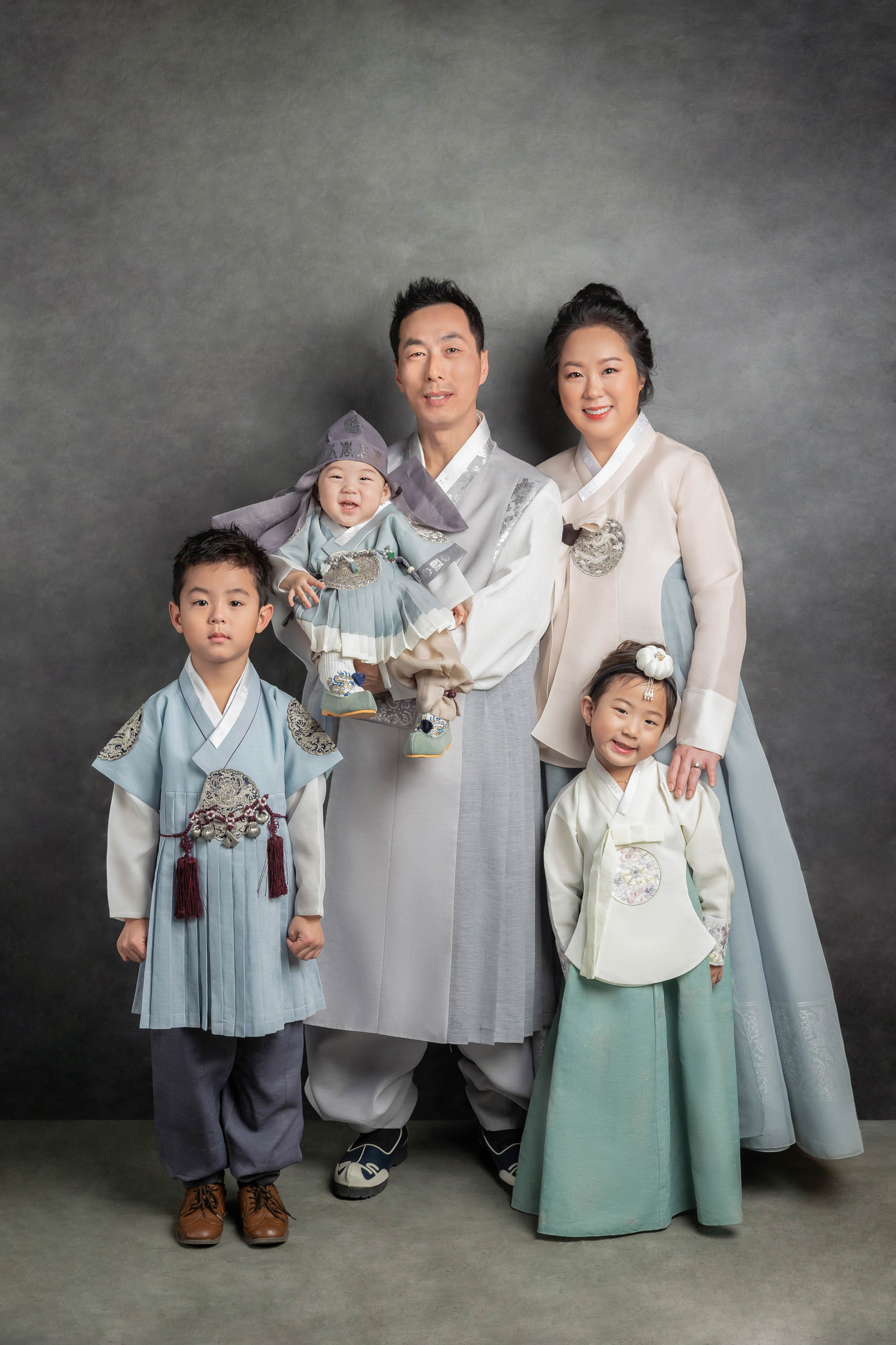 Parents and children wearing hanbok in a studio portrait