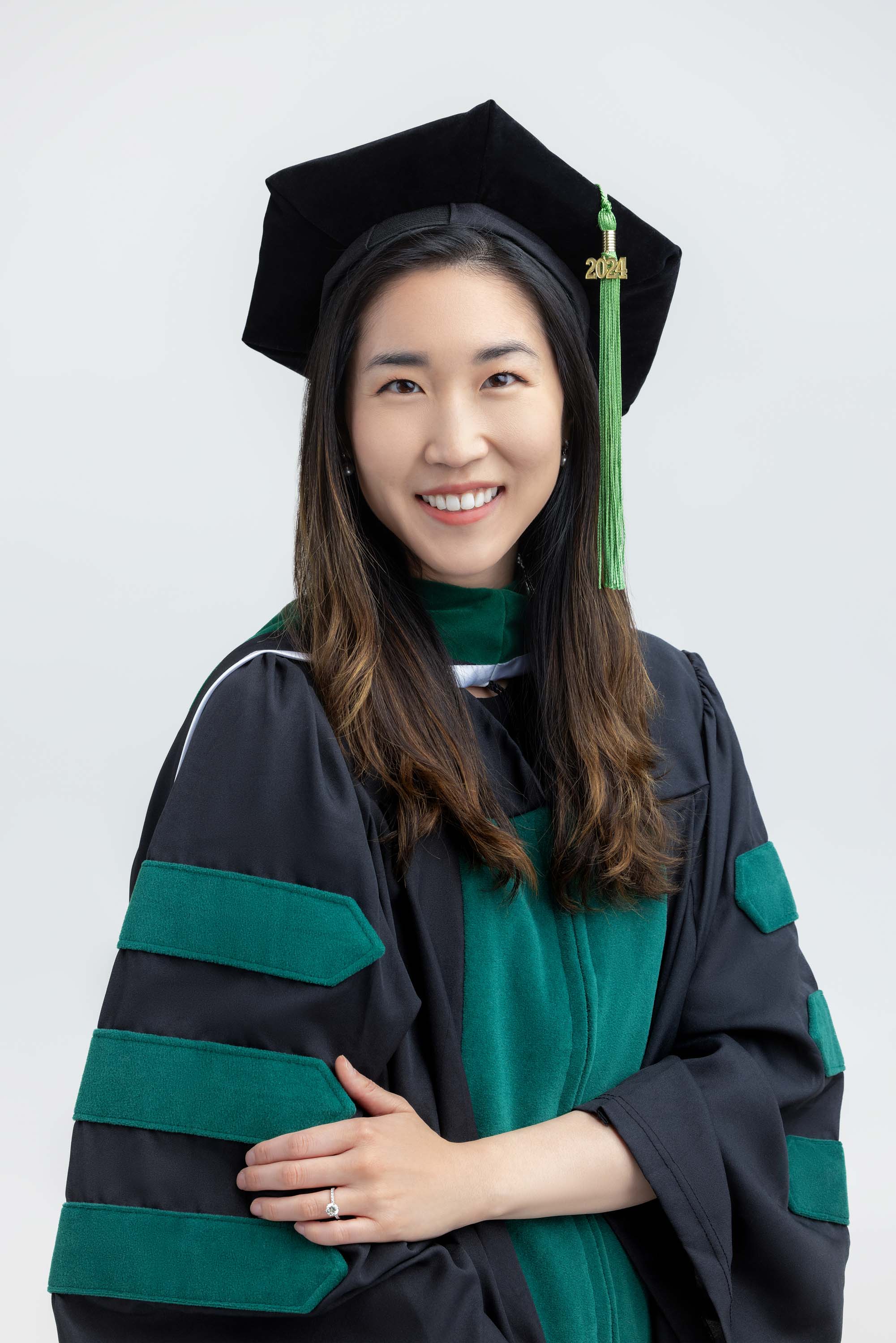 Graduate in cap and gown against a light background
