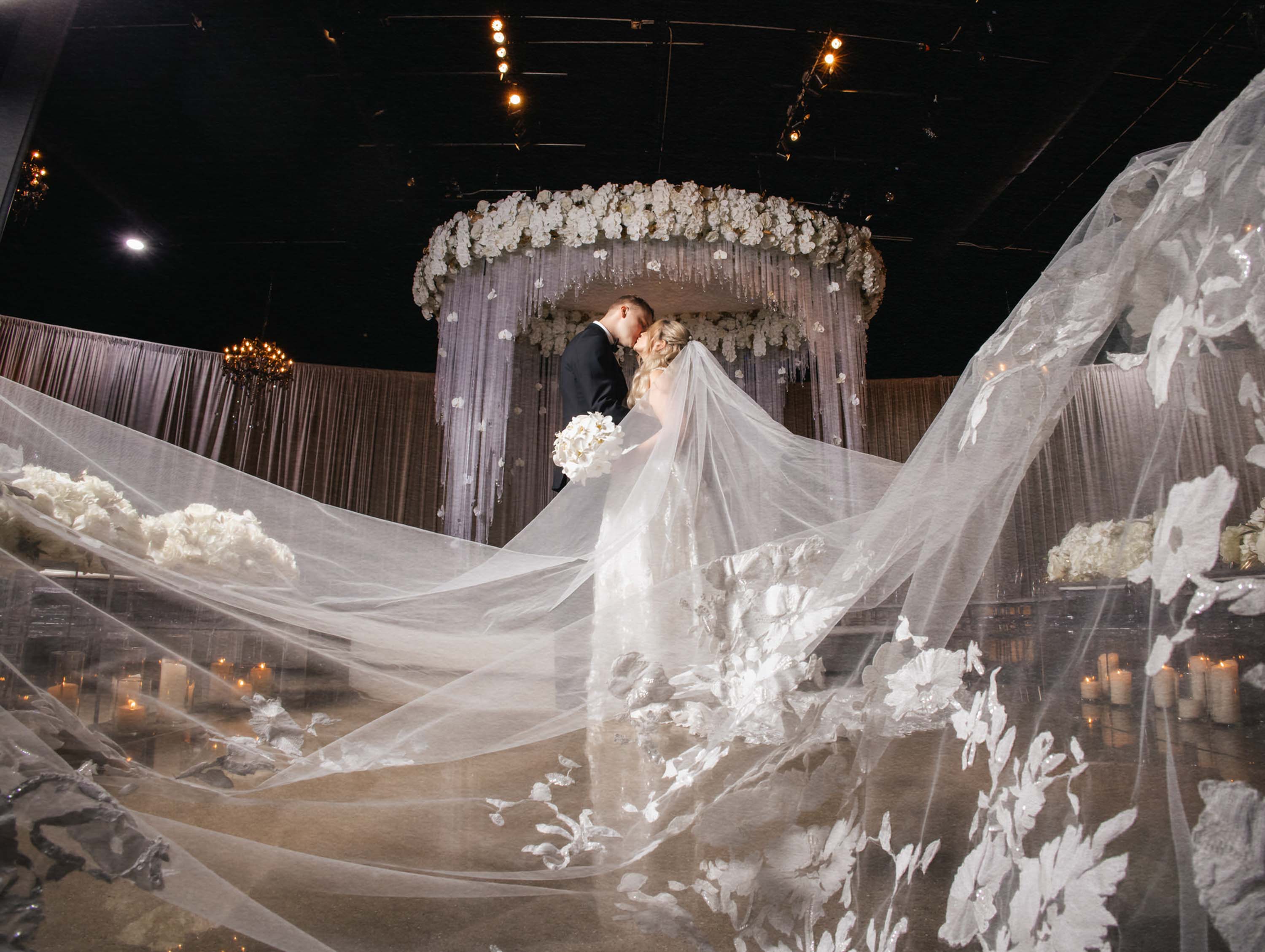 Couple kissing through the bride’s veil